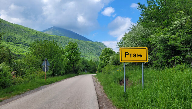 A view of the top of Mount Rtanj and a sign written in Cyrillic