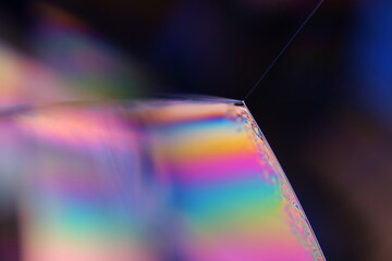 Bright rainbow reflection of liquid on black background, blue colours, surrealistic pattern,...