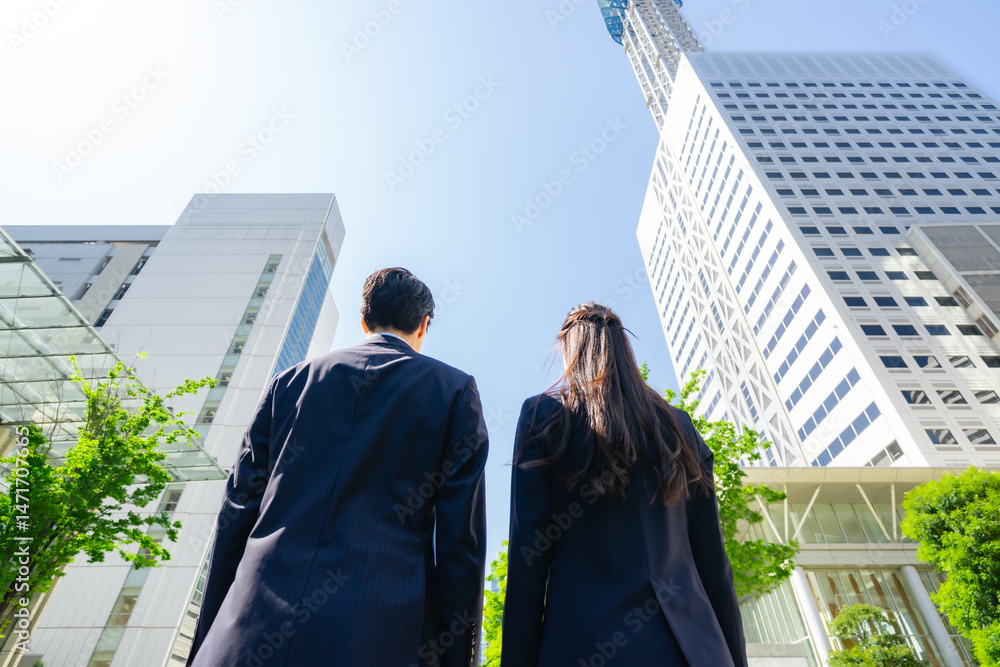 Poster 新緑の街で空を見上げる男女ビジネスパーソンのグループの後ろ姿のアオリ構図