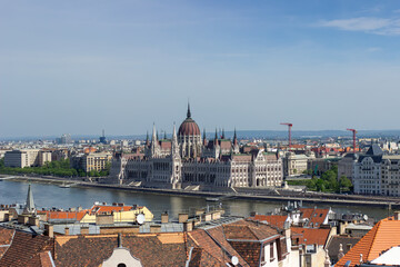 Panoramic view of Budapest city with Parliament building, Danube River, bridges and green trees under clear blue sky