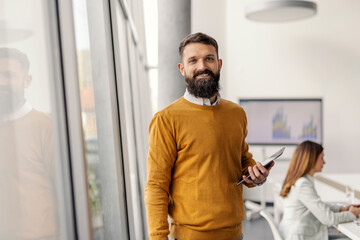 Portrait of white collar worker standing at boardroom with tablet in hands during the meeting and...