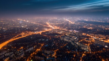Fototapeta premium Stunning aerial shot of a city illuminated at night, showing a network of glowing street lights and busy roads stretching across the urban landscape