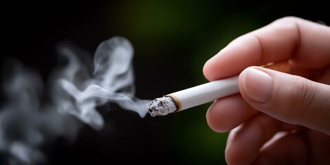A hand holding a cigarette with smoke swirling upward, representing smoking's impact on health and society.