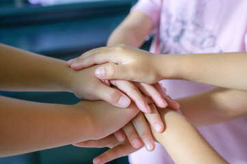 Team Huddle A friendly family joins their hands as a sign of joint success Stack of hands, below and children in nature for unity, support and friendship, girls stacking hands together in teamwork