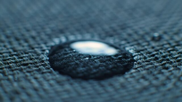 View a close-up of water droplets forming on a fabric surface. This demonstration highlights the effectiveness of waterproof technology and showcases material resistance to liquid penetration.