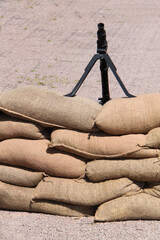 A Vintage Wartime Machine Gun on a Sandbag Barrier.