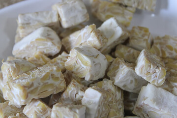 Tempeh pieces on a plate. Raw tempeh ready to be cooked