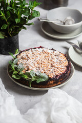 Round Pie with black currants and mint in a plate on the table. Dessert