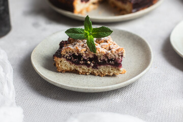 Round Pie with black currants and mint in a plate on the table. Dessert