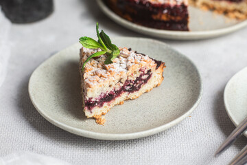 Round Pie with black currants and mint in a plate on the table. Dessert