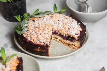 Round Pie with black currants and mint in a plate on the table. Dessert
