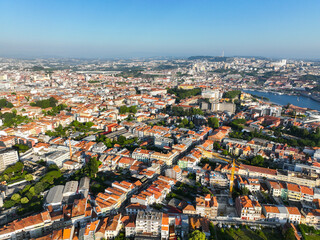 Wide aerial view of Porto, Portugal with dense rooftops, parks, and historic city blocks