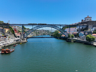 Low aerial view of Dom Luís I Bridge and riverbank on a clear summer day