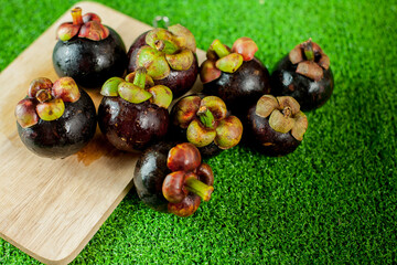 Fresh mangosteen fruits and cross section showing the thick purple skin and white flesh.