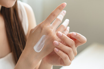 Health skin care, beauty smile asian young woman, girl  hand applying, putting moisturizer on her...