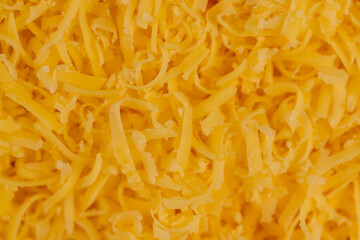 grated cheese of orange color, grated cheese preparation for adding to dishes, close up