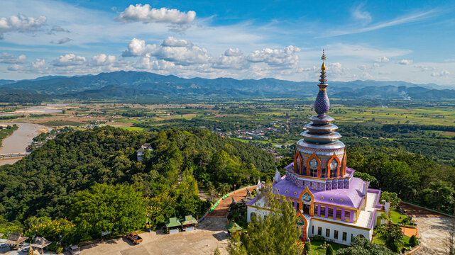 Aerial view of a colourful pagoda overlooking a green valley. pagoda at Wat Thaton on the banks of the Kok River in Chiang Mai Province near the border with Burma..fantastic pagoda of the tribal