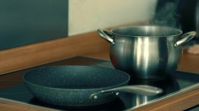 Turning on induction cooktop to heat frying pan. Activating touch control to start cooking process. Pressing sensor button to power up stove. Setting temperature for preheating non stick skillet