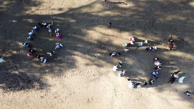 Video of Argentine chacarera dancers dancing in a circle, aerial view from a drone	
