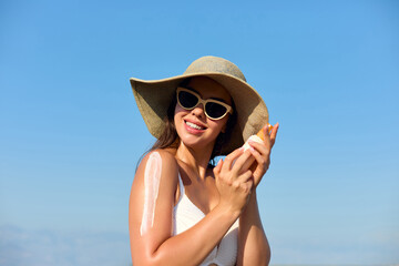 Beautiful Woman in Bikini Applying Sun Cream on Tanned Shoulder. Sun Protection. Skin and Body Care Concept. Girl Using Sunscreen to Skin. 