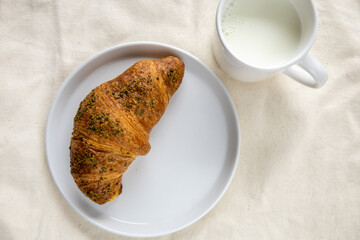 pistachio croissant and milk on natural linen
