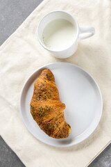 pistachio croissant and milk on natural linen