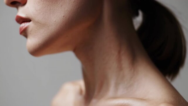 Woman showing neck and collarbones on white background