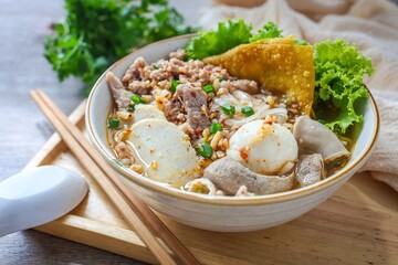 Thin rice noodles  tom yum soup with meatball and minced pork in a ceramic bowl 