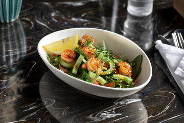 Portion of gourmet salad with fresh vegetables and shrimp