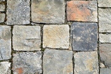 Detailed Cobblestone Pavement Texture with Gray and Earth Tone Blocks in a Repeating Square Pattern Ideal for Urban and Architectural Backgrounds