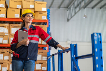 Female engineer inspecting warehouse while holding tablet, managing inventory and monitoring operations, applying smart factory technology in logistics, supply chain and industrial storage environment