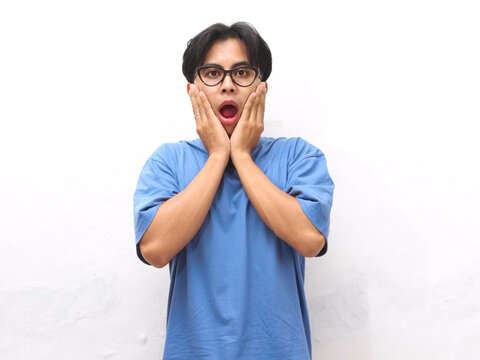 Portrait of shocked and Amazed Asian man looking at the camera. shocked face Asian man looking at empty space at left. Amazed and feels shocked asian man. Indonesian man with surprised expression.