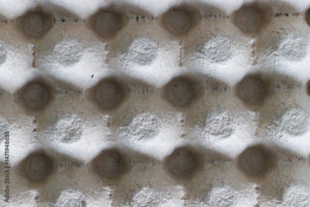 Poster close-up of a textured cardboard material with hexagonal patterns, showcasing natural hues and shado