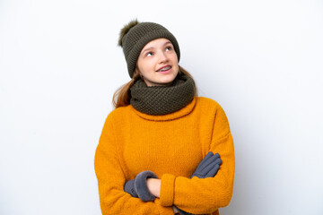 Teenager Russian girl wearing winter jacket isolated on white background looking up while smiling