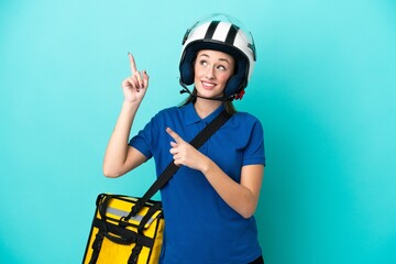 Young caucasian woman with thermal backpack isolated on white background pointing with the index finger a great idea