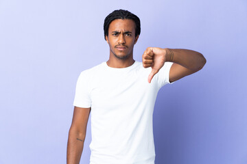 Young African American man with braids man isolated on purple background showing thumb down with...