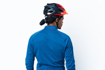 Young cyclist man with braids over isolated background in back position and looking side
