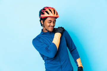 Young cyclist man with braids over isolated background suffering from pain in shoulder for having made an effort