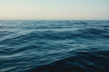 Obraz premium Calm Blue Ocean Water with Gentle Ripples and Clear Horizon Under a Pale Sky Creating a Serene Natural Seascape