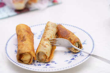 Delicious dessert rolls served on a floral plate with fork ready for tasting