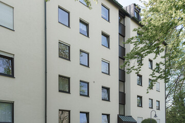Apartment building on a sunny day with green trees in a residential area