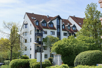 Residential building surrounded by greenery in a suburban area on a sunny day