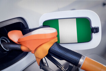 The Nigeria flag on the lid of the gas tank of a car at a gas station in close-up. High or low...
