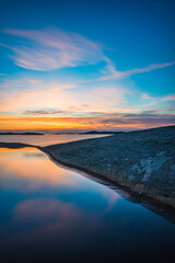 Fototapeta premium Coastal sunset reflects vibrant colors over calm waters near Gothenburg