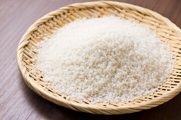 Raw Japanese rice in a bamboo sieve