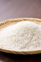 Raw Japanese rice in a bamboo sieve