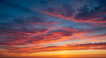 Fototapeta premium Fiery Sky: Breathtaking Sunset Cloudscape in Brilliant Orange & Blue Hues | Nature's Canvas