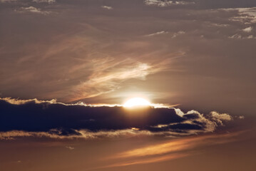 Soleil caché derrière un nuage au coucher de soleil