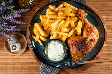 Crispy roasted chicken leg with french fries.