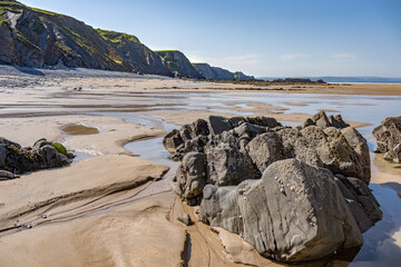 Low tide reveals large rocky landscape on Cornwall sandy beach